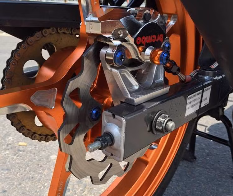 Tương tự như phanh trước, hệ thống phanh sau cũng đã được độ lại với đĩa Galfer và heo Brembo Billet Nickel 2 pis đối xứng, đi kèm pad CNC. Cuối cùng, những chi tiết bắt ốc titan Proti tạo điểm nhấn trên nền sơn đen bóng của chiếc xe.