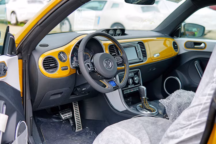 Nội thất của Beetle Dune cũng được hoàn thiện độc đáo hơn với các tấm ốp nhựa sơn màu trùng với ngoại thất, ghế bọc da 2 tông màu và chần chỉ tương phản. Xe được tích hợp sẵn hệ thống thông tin giải trí với màn hình 6,3 inch với đầy đủ các tính năng như kết nối smartphone, Bluetooth, camera lùi...