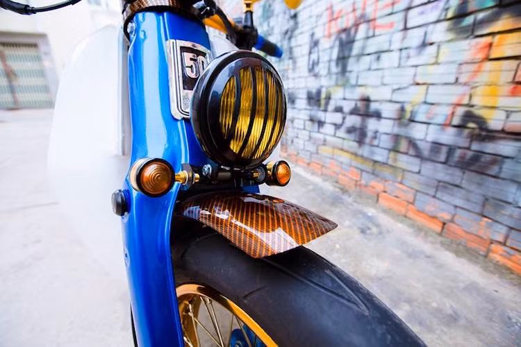 Những chiếc Street Cub luôn được độ lại với bánh có bề rộng vành và lốp lớn hơn so với xe nguyên bản. Đi theo phong cách Street Cub, chiếc Little Cub này đã được trang bị đôi vành nan 17 inch màu vàng bắt mắt kèm theo lốp lớn hơn.