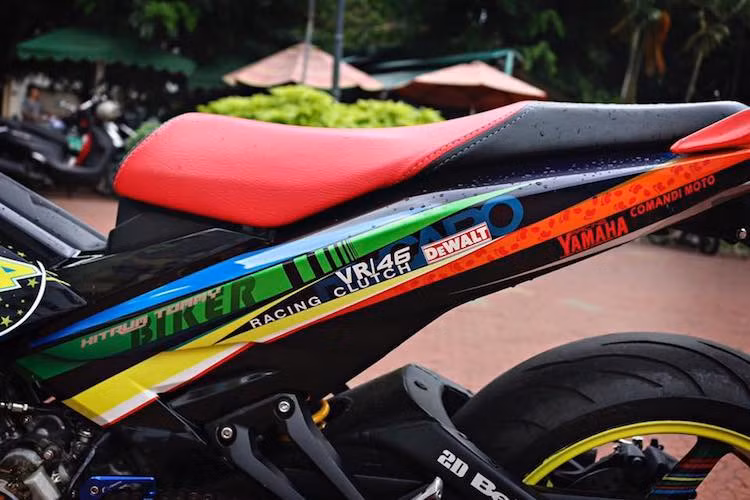 Dàn vỏ với thiết kế nguyên bản của Exciter 150 vẫn hoàn toàn được giữ nguyên. Giống như lần đầu xuất hiện cách đây gần 2 năm, chiếc xe vẫn được sơn tem đấu phong cách Valentino Rossi. Bộ yên xe cũng đã được bọc lại với 2 tông màu thể thao.