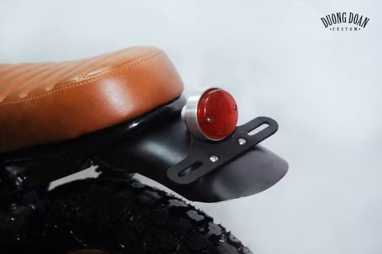 Thay vì phần đuôi nhựa phía sau, GD110 nay chỉ còn lại một dè nhôm ngắn được tích hợp pad biển số kiêm đèn hậu phong cách hãng Kijima của Nhật. Kết thúc bản độ là bộ yên bọc da kiểu "bánh mì" quen thuộc trên các bản độ xe nam tại Việt Nam.