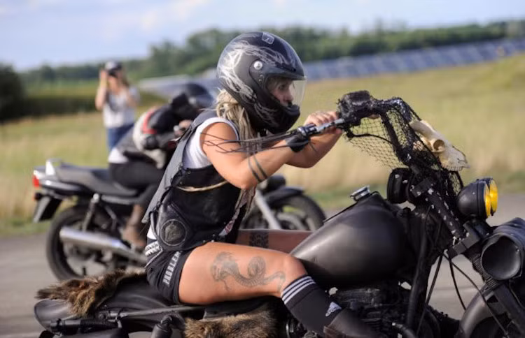 Một phụ nữ xuất hiện vô cùng “hầm hố” và cũng đầy gợi cảm trên chiếc mô tô phân phối lớn, chuẩn bị bước vào cuộc đua.