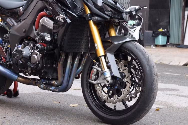 Trên bản độ này, "dàn chân" trước của chiếc xe đã được độ lại khá "khủng", với chi tiết đắt giá nhất là cặp phuộc Ohlins FGRT. Bên cạnh đó, chiếc xe còn có hệ thống phanh trước với dây dầu Hel và cặp heo Brembo M50. Dè trước bằng sợi carbon thêm chất thể thao cho thiết kế tổng thể của xe.