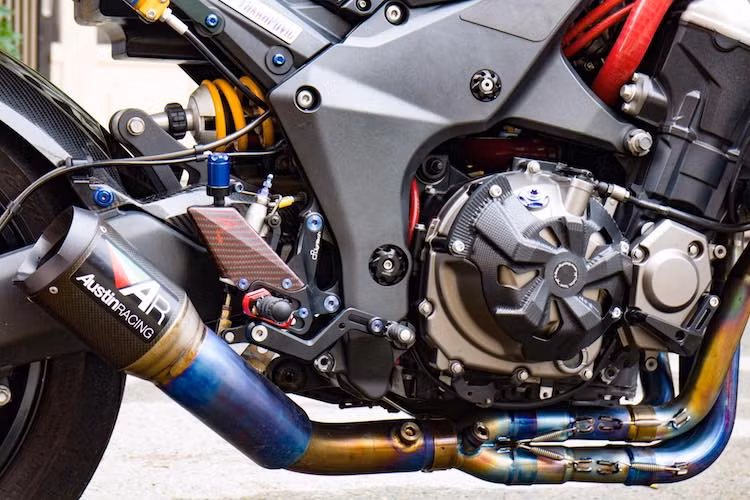 Hai bên thân xe là cặp đèn LED gắn trên chống đổ. Động cơ nguyên bản của Z1000 vốn đã rất mạnh mẽ, chính vì vậy chủ xe chỉ bổ sung ống giải nhiệt Samco và bộ chống đổ 2 bên lốc T-Rex. Với hệ thống xả full system gồm lon pô Austin Racing và cổ pô titan, tiếng nổ từ động cơ 4 máy càng trở nên uy lực hơn.