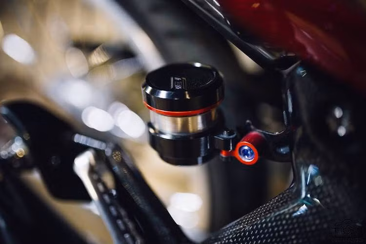 Chắn xích không phải là bộ phận duy nhất trên chiếc Exciter này được bọc carbon, khi dàn để chân của xe cũng được hoàn thiện tương tự. Hệ thống phanh sau cũng được nâng cấp, bắt đầu từ bình dầu titan AEM.