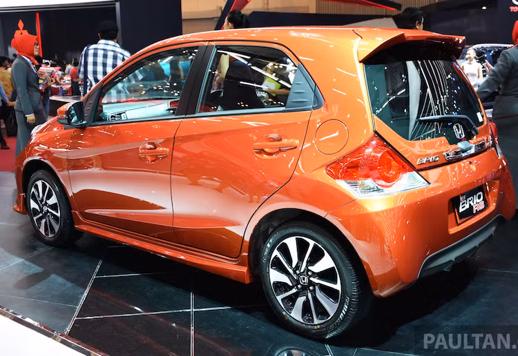 Ở hai bên thân xe, Honda cũng không quên trang bị cho Brio RS bộ mâm đúc 15 cánh 2 tông màu mới, với lốp 185/55 cho cả 4 bánh. Trong khi đó, cản sau của xe cũng được thiết kế lại với phần dưới được tạo hình "giả" cánh khuếch tán khí động học. Màu sơn cam ánh ngọc Phoenix Orange Pearl kết thúc các thay đổi của xe.