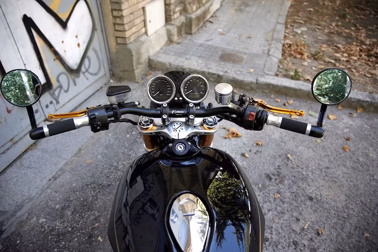 Tay lái nguyên bản trên xe được thay bằng ghi-đông Rizoma để phù hợp hơn với phong cách Brat, cùng với những "đồ chơi" nhẹ nhàng như tay phanh/côn CNC nhôm, bao tay Rizoma, gương hậu gắn gù.