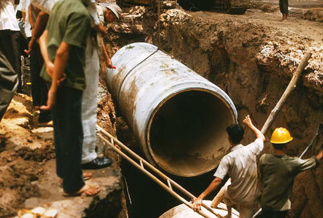 Đoạn đường ống được đưa xuống hố an toàn. Ảnh: Saigoneer.