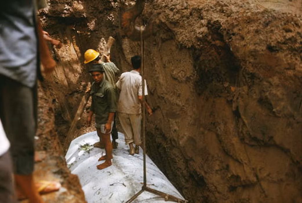 Cố định vị trí đường ống trong hố. Ảnh: Saigoneer.