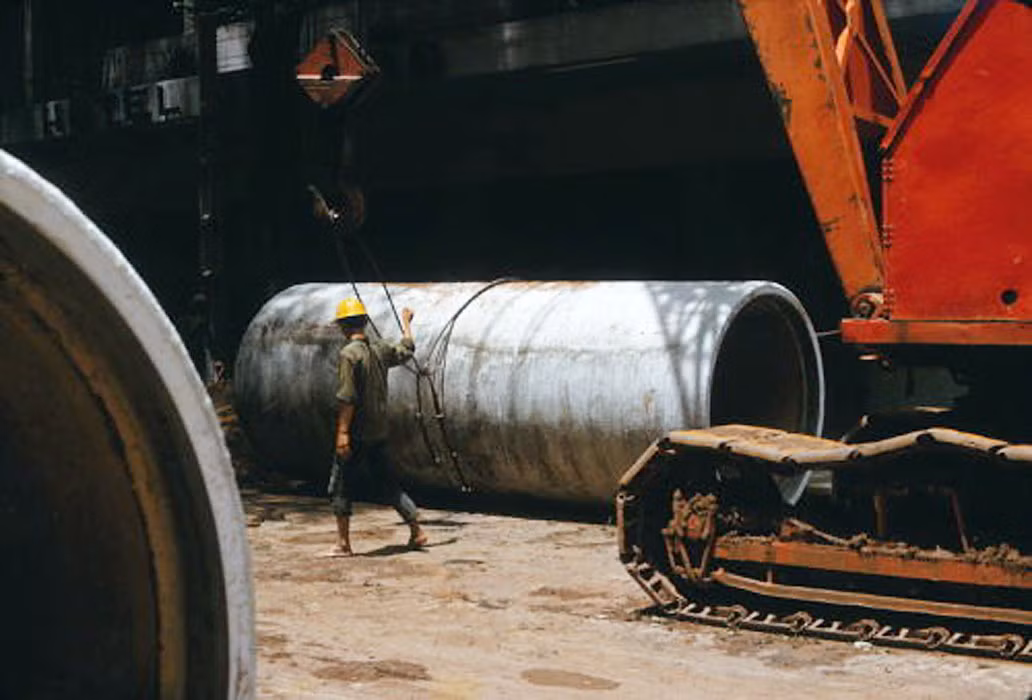 Công nhân buộc dây cáp vào ống. Ảnh: Saigoneer.