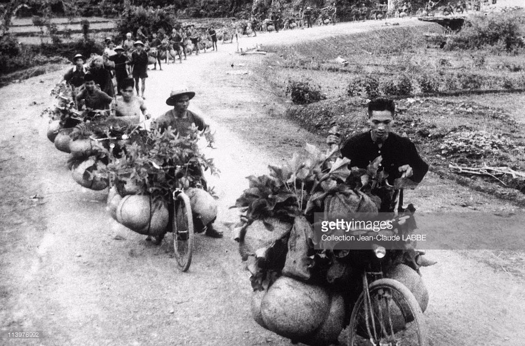Dân công hỏa tuyến thồ gạo cung cấp cho mặt trận. Ảnh: Getty.