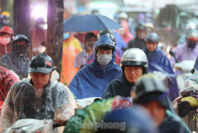 Người dân đi làm trong cơn mưa tầm tã... (Ảnh: Tiền Phong)