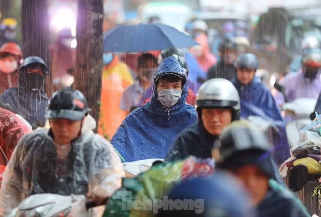 Người dân đi làm trong cơn mưa tầm tã... (Ảnh: Tiền Phong)