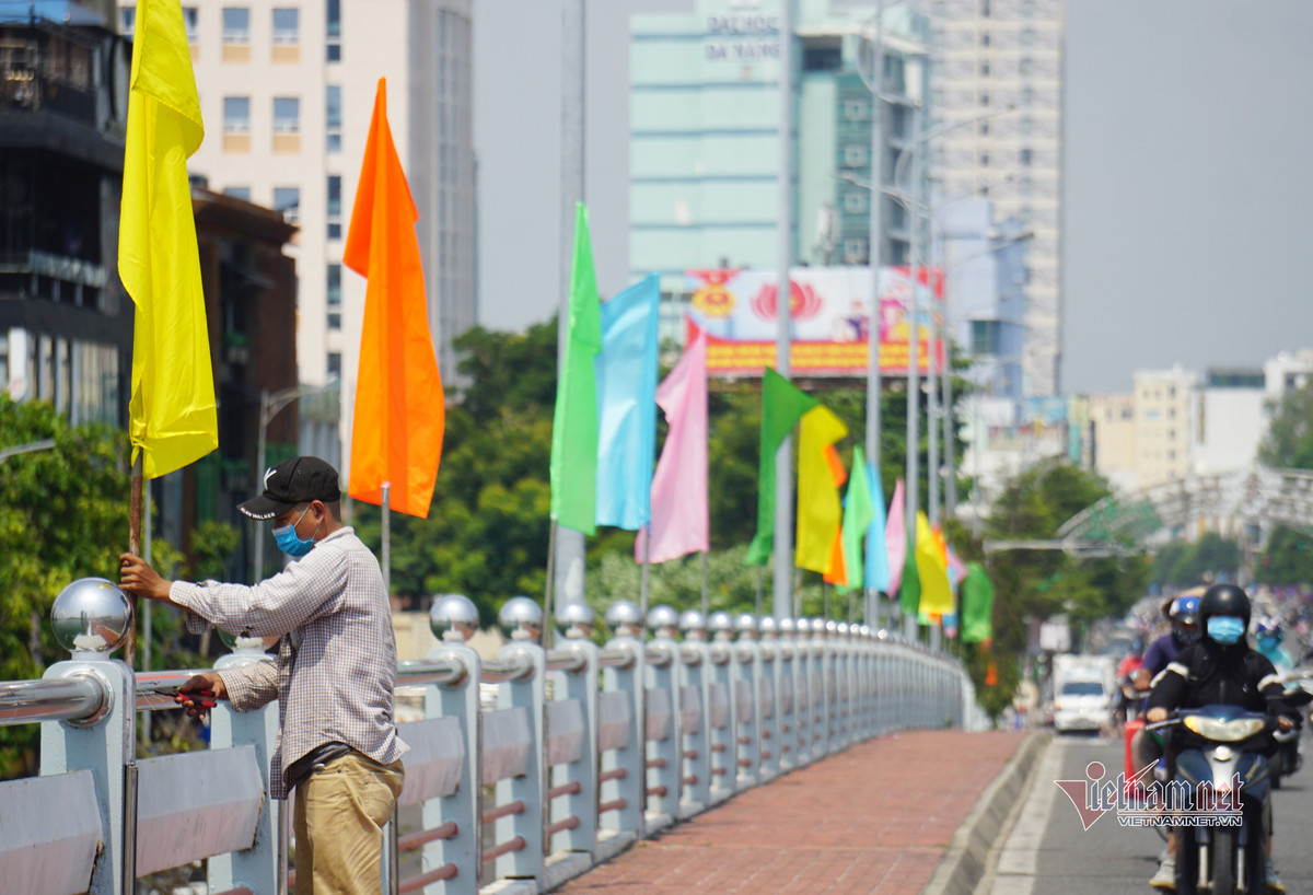 Công nhân treo cờ ở cầu Sông Hàn. Dịp lễ 30/4 và 1/5, dự kiến sẽ có 130.000 nghìn lượt du khách đến Đà Nẵng tham quan.