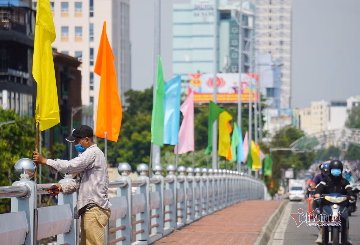 Công nhân treo cờ ở cầu Sông Hàn. Dịp lễ 30/4 và 1/5, dự kiến sẽ có 130.000 nghìn lượt du khách đến Đà Nẵng tham quan.