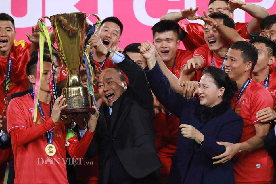 Thủ tướng Chính phủ Nguyễn Xuân Phúc và Chủ tịch Quốc hội Nguyễn Thị Kim Ngân cùng các tuyển thủ của đội tuyển Việt Nam nâng cao chiếc cúp vô địch AFF Cup 2018.