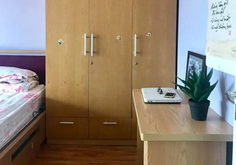 Trong phòng ngủ của 2 vợ chồng, chiếc tủ quần áo to được đặt ở giữa. Bên cạnh là bàn làm việc. Chiếc bàn đã cũ, có vẻ như lâu ngày chưa được sử dụng.