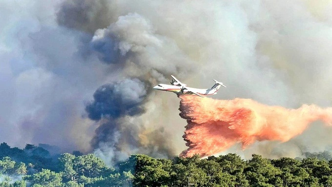 Pháp dùng máy bay cánh quạt phun chất hóa học giúp làm chậm tốc độ lây lan của đám cháy. Ảnh: Twitter.