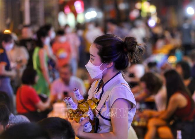 Nhân viên phục vụ tất bật với đồ uống trên tay.