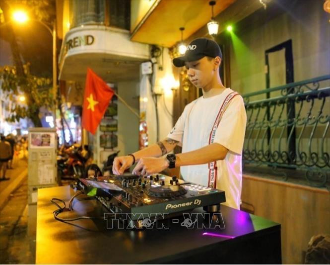 Một DJ chơi nhạc tại một quán bar trên vỉa hè.