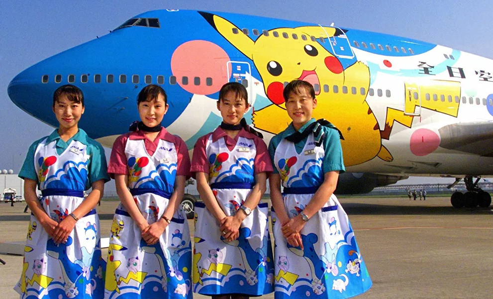 Các nữ tiếp viên của hãng hàng không Nhật Bản All Nippon Airways bên cạnh chiếc máy bay Pokemon (Pocket Monsters) năm 1999.
