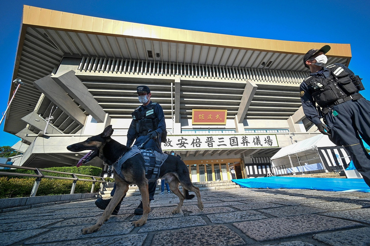 Các nhân viên cảnh sát và một chú chó nghiệp vụ đứng bảo vệ trước Nippon Budokan, nơi tổ chức lễ tang cấp nhà nước của cựu Thủ tướng Abe. Ảnh: Reuters, Getty. 