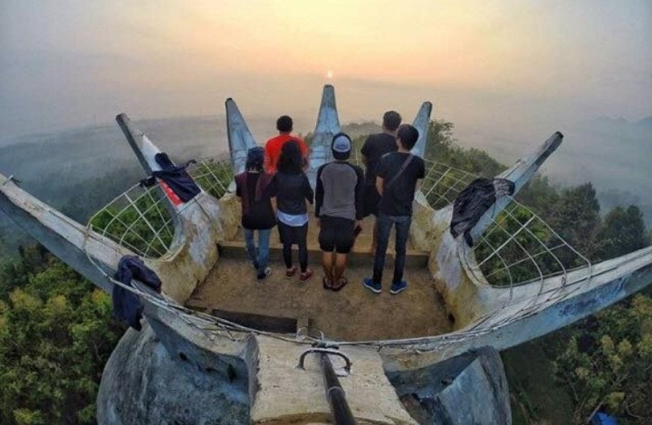 Du khách thích thú ngắm bình minh ở trên đỉnh nhà thờ Con Gà ở Indonesia. Ảnh: IT.