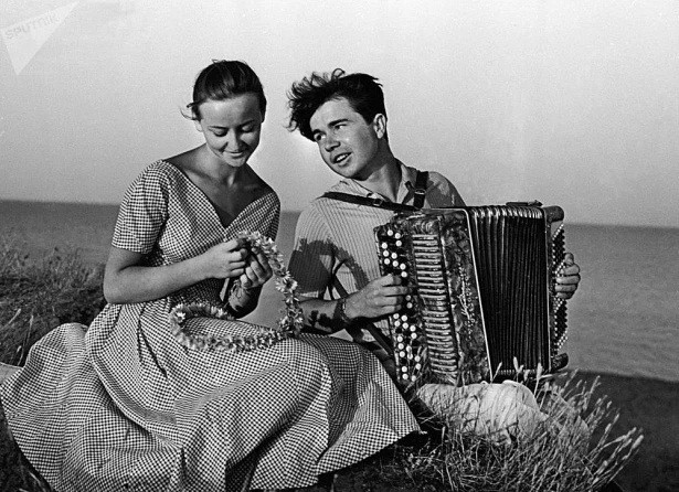 Cô gái Liên Xô e ấp bên cạnh chàng trai đang chơi đàn. Ảnh: ER, Sputnik.