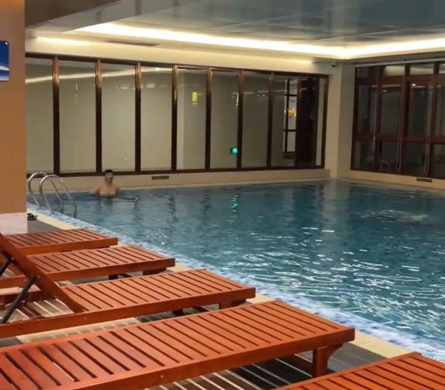 Tầng 1 của tòa chung cư có hồ bơi bốn mùa khép kín hiện đại cùng bàn ghế phục vụ nhu cầu bơi lội của các cụ ông cụ bà.
