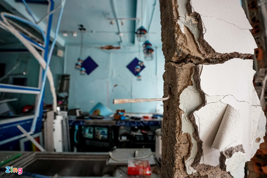 Bức tường nhà bên cạnh căn xảy ra nổ bị đổ sập, chỉ còn một phần. Nhiều đồ dùng sinh hoạt hư hỏng. Gia chủ phải chuyển đi nơi khác ở tạm chờ sửa chữa.