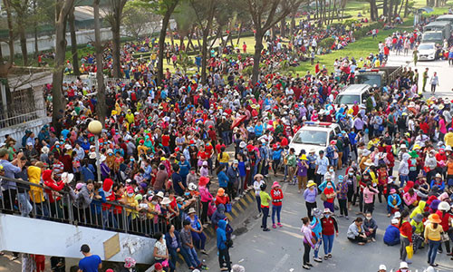 Hàng ngàn công nhân đứng bên ngoài cổng công ty và quốc lộ 1K - Ảnh: A LỘC