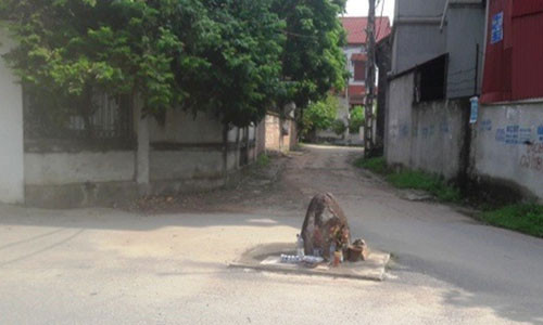 Hòn đá nằm giữa ngã ba của làng Vèo nhưng không ai dám động tới (Ảnh: Đào Tấn).