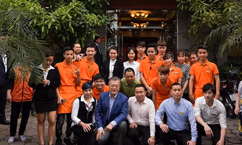 Tổng thống Hàn Quốc Moon Jae-in chụp ảnh lưu niệm với đại diện cửa hàng và các nhân viên phuc vụ - Ảnh: NGUYỄN KHÁNH