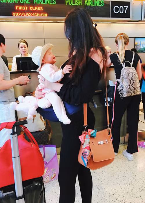 Bé Bồ Câu tươi rói bên mẹ tại sân bay. Sau khi lấy chồng, sinh con, Phan Như Thảo lui về ở ẩn.