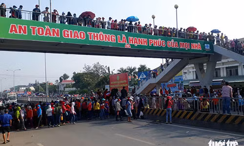 Công nhân công ty Pouchen chắn ngang quốc lộ 1K, đoạn đi qua xã Hóa An, TP Biên Hoà, Đồng Nai khiến giao thông tắc nghẽn - Ảnh: A LỘC