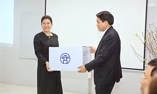 Bà Đỗ Thị Kim Liên, Chủ tịch Nhà máy nước mặt Sông Đuống - đại diện BQL Dự án - nhận quà động viên từ Chủ tịch UBND TP Hà Nội Nguyễn Đức Chung.