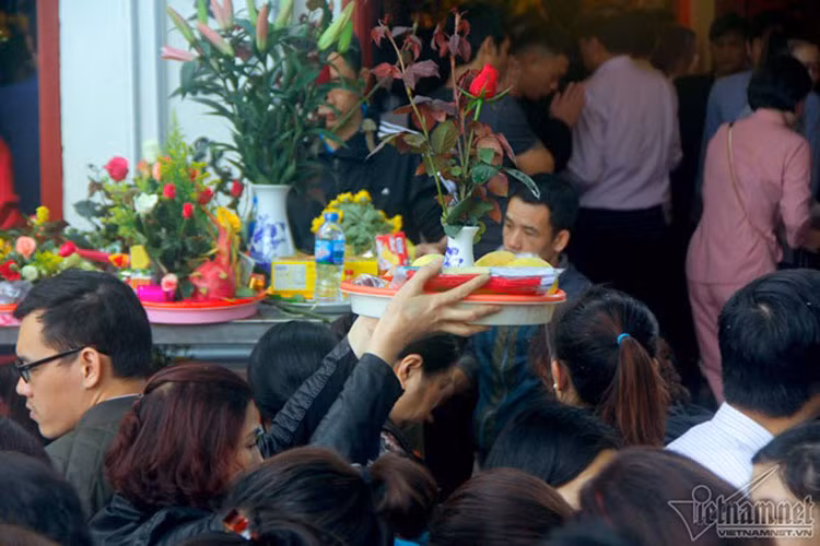 Dòng người đông đúc nên người người phải bê cao mâm lễ.