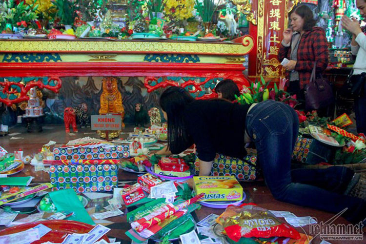 Ai cũng cố gắng chen chân để đặt được mâm lễ của mình gần điện thờ chính của phủ Tây Hồ. Một phụ nữ cố trườn người để đưa mâm lễ vào sâu bên trong. Ai cũng cố gắng chen chân để đặt được mâm lễ của mình gần điện thờ chính của phủ Tây Hồ. Một phụ nữ cố trườn người để đưa mâm lễ vào sâu bên trong.