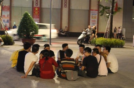 Nhiều bạn trẻ ngồi tụm lại trò chuyện, đàn hát vui vẻ.