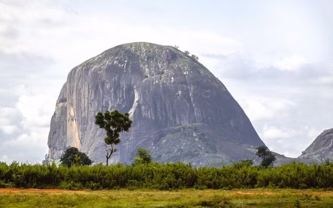 Zuma Rock, một tảng đá nguyên khối có mái vòm khổng lồ cao khoảng 298 mét, ở vùng Nigeria. Từ năm 1999, hình ảnh Zuma Rock được in trên tờ tiền 100 naira (đơn vị tiền tệ Quốc gia của Nigeria). Nguồn: peeterv /Getty Images.