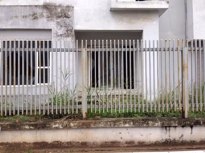 Biệt thự bạc tỷ bỏ hoang, cỏ mọc um tùm, hàng rào sắt hoen rỉ.