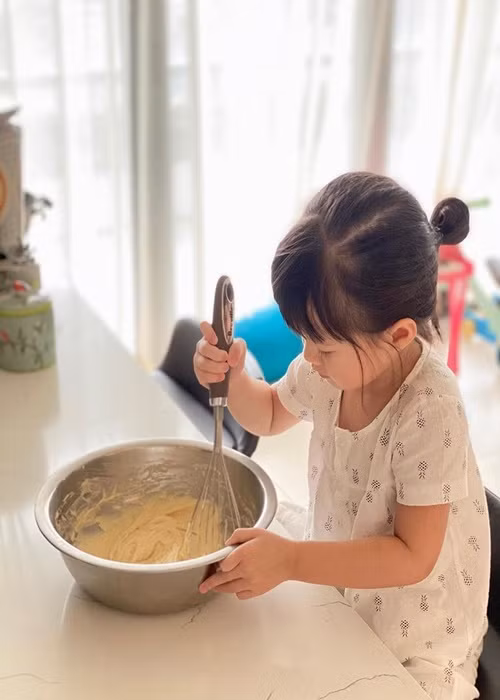 Nàng hoa hậu khoe con gái đầu lòng phụ làm bánh. Ảnh: FB Thu Thảo