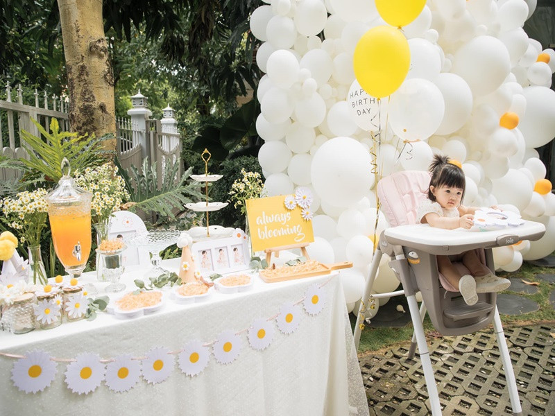 Tiệc sinh nhật của bé Winnie cùng gia đình nhà nội được trang trí theo thông màu trắng - vàng.