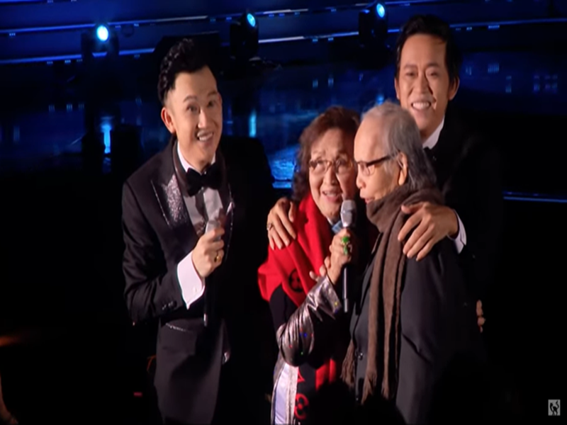 Hoài Linh cho hay: “Bố mẹ đã làm tất cả cho chúng con. Những gì hiện tại chúng con đang có, từ đầu óc, thân thể tới tất cả bản năng để chống chọi lại cuộc đời đều đến từ bố mẹ. Ngay đến cái bệnh con đang mang trong người cũng một nửa của bố và một nửa của mẹ. Chóng mặt, đau lưng, đau khớp là của mẹ. Đau tim, đau bao tử là của bố. Con người con được chia ra từ bố và mẹ. Da trắng là của bố, đồi mồi là của mẹ, con đều có. Con muốn nói những lời này với bố mẹ vì con không biết rằng anh em chúng con còn đứng trên sân khấu được bao lâu nữa để nhìn thấy bố mẹ ngồi và xem chúng con hát như thế này”. Ảnh: Vietnamnet