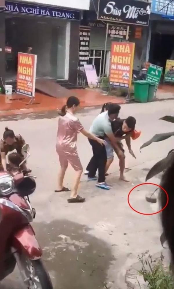 Người vợ đánh ghen nên túm chặt tóc của cô bồ nhí để mắng chửi và đánh đập, còn người mẹ đi cùng dùng dép để tát tới tấp vào đầu "tiểu tam". Ảnh: Tổng hợp