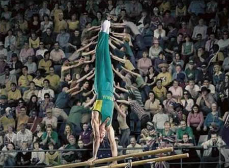 Không rõ những cổ động viên đang làm gì nhưng nhìn từ góc máy này dường như họ đang giúp anh chàng vận động viên thể dục dụng cụ giữ thăng bằng.