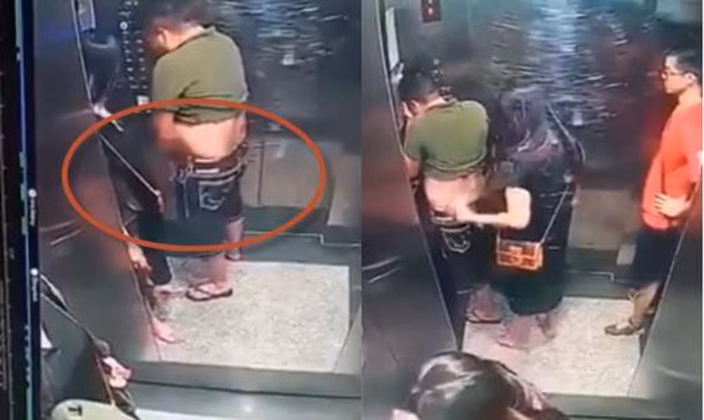 Người phụ nữ đi cùng che chắn cho người đàn ông, đồng thời che mặt của mình lại. Toàn bộ sự việc được camera trong thang máy ghi lại.