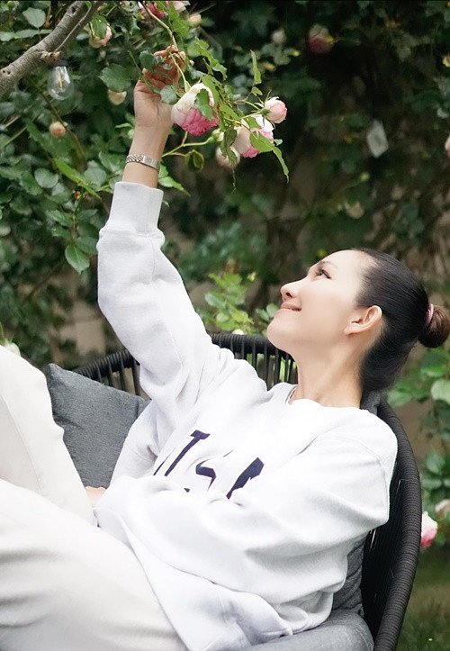 Nữ diễn viên ngồi ngắm hoa hồng trong một buổi sáng.