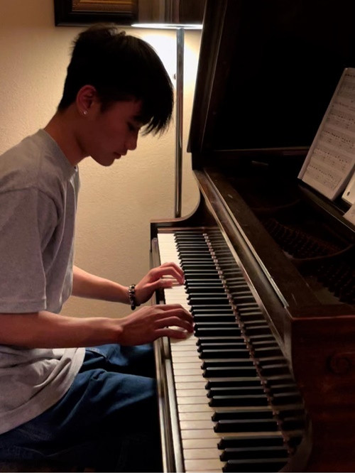 Nữ diễn viên ngắm con trai đánh đàn.
