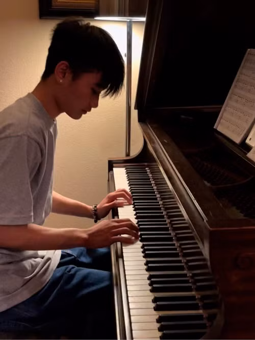 Nữ diễn viên ngắm con trai đánh đàn.